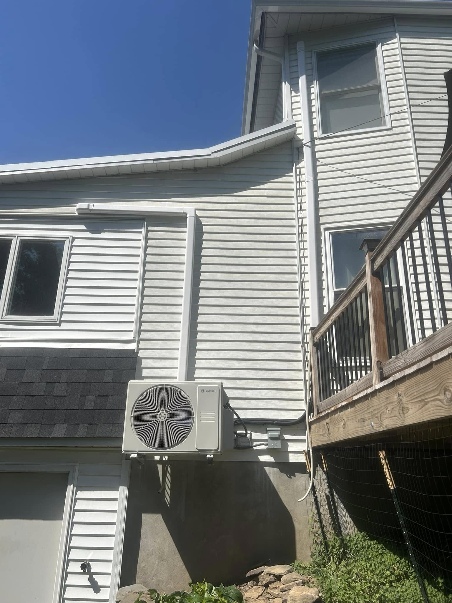 Wall-mounted outdoor air conditioning unit on a home exterior