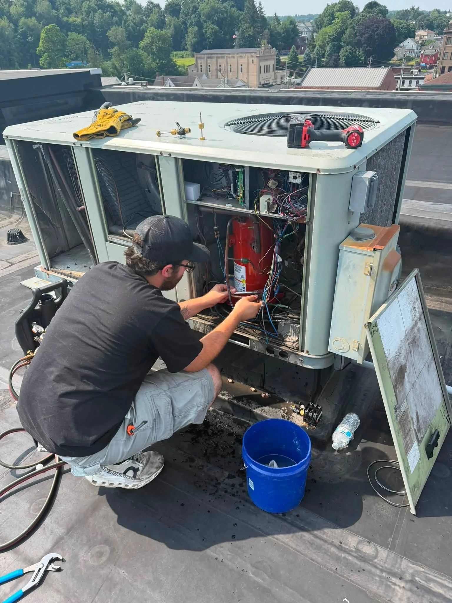 Technician repairing a rooftop air conditioning unit
