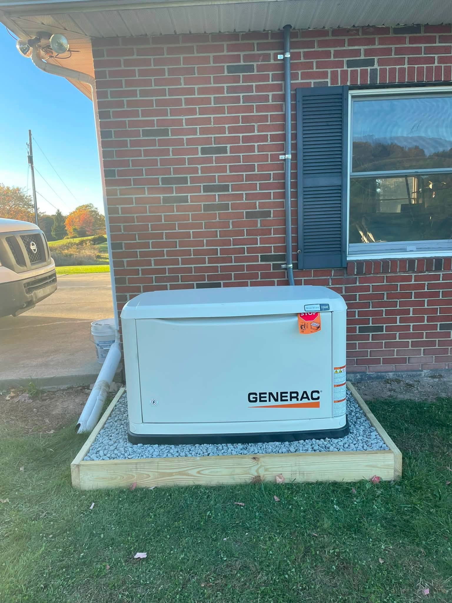 Generac Guardian standby generator beside a brick home