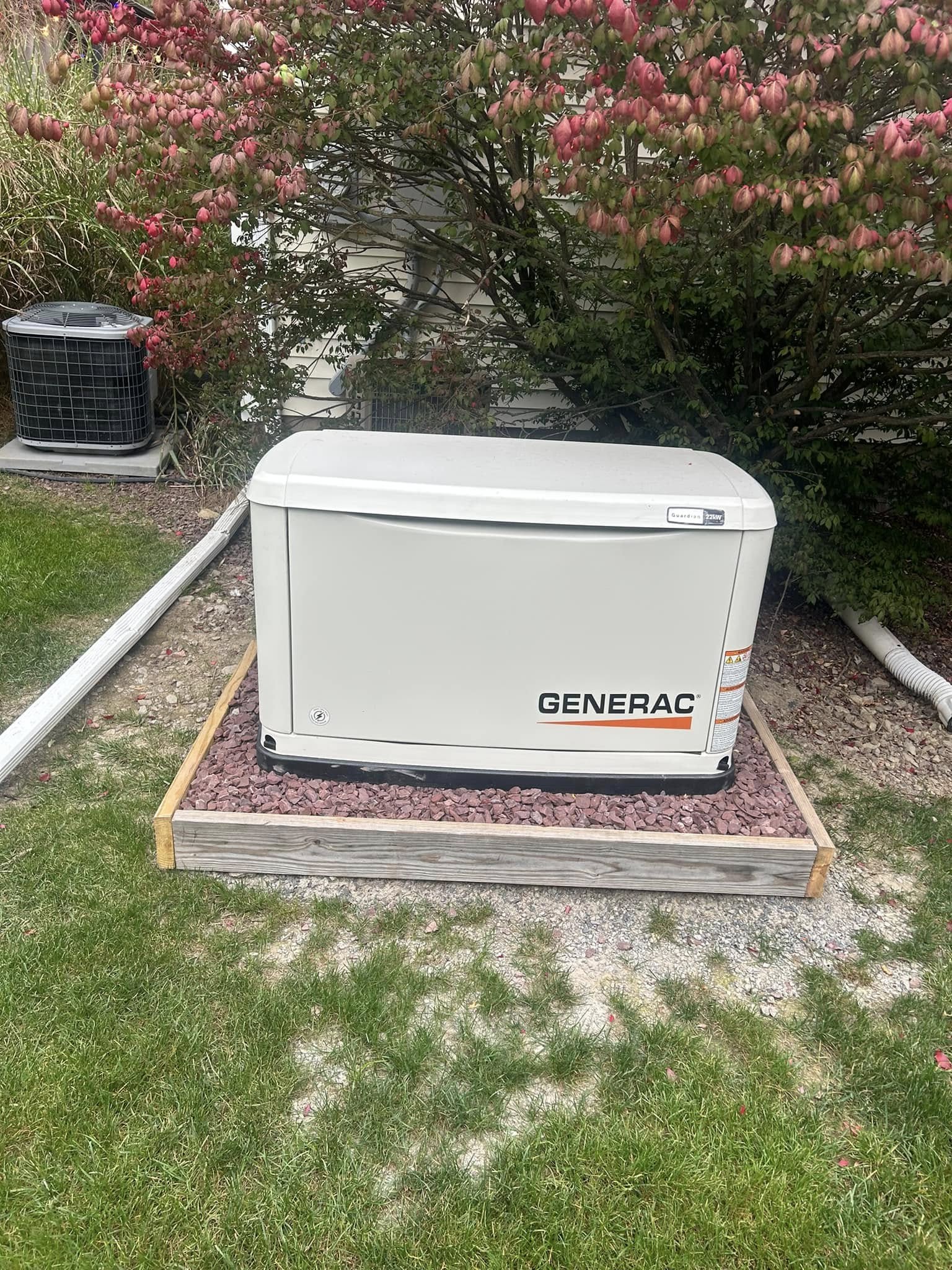 Front view of a Generac Guardian standby generator near landscaping