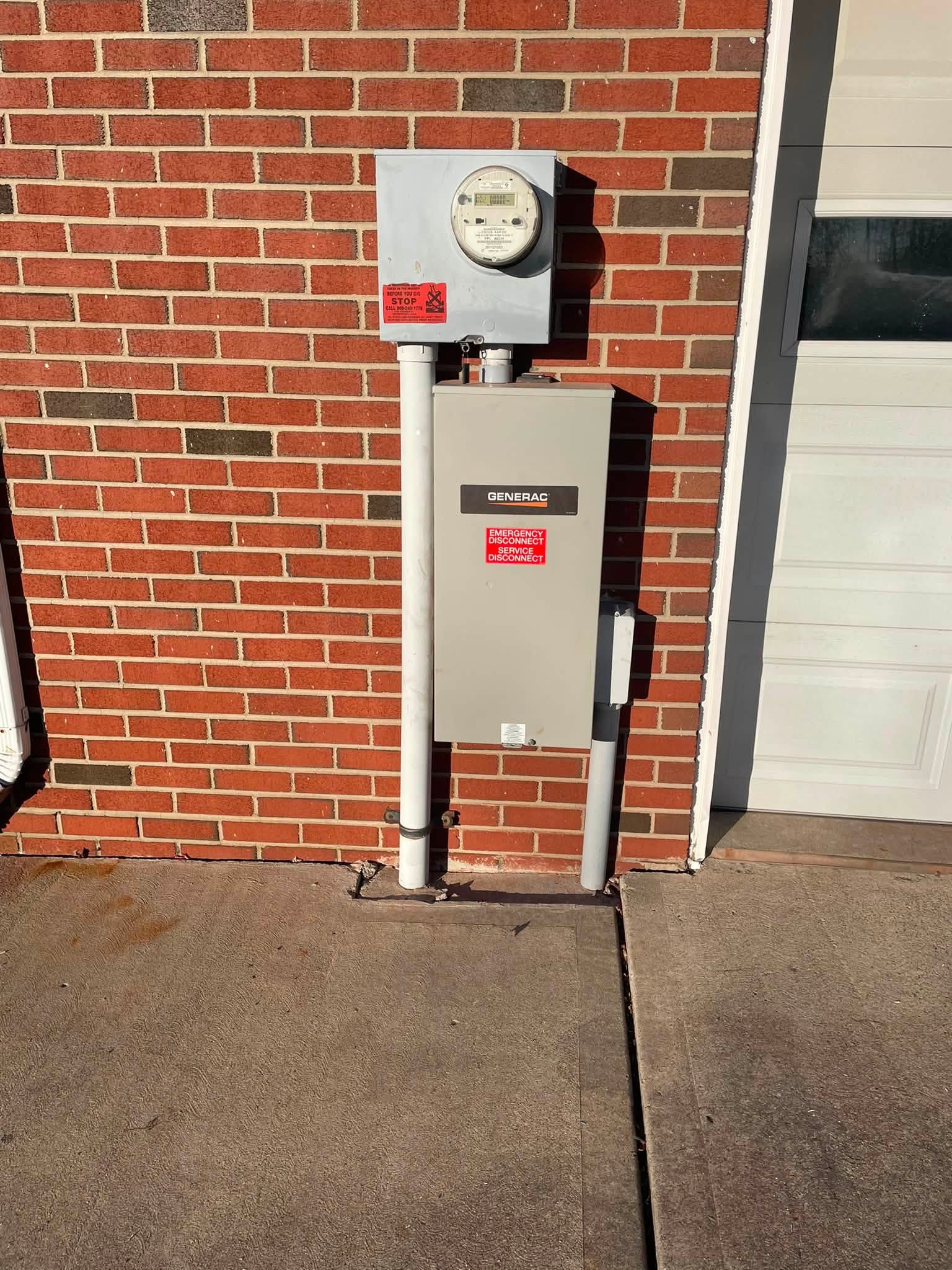 Generac transfer switch and electric meter mounted on a brick wall