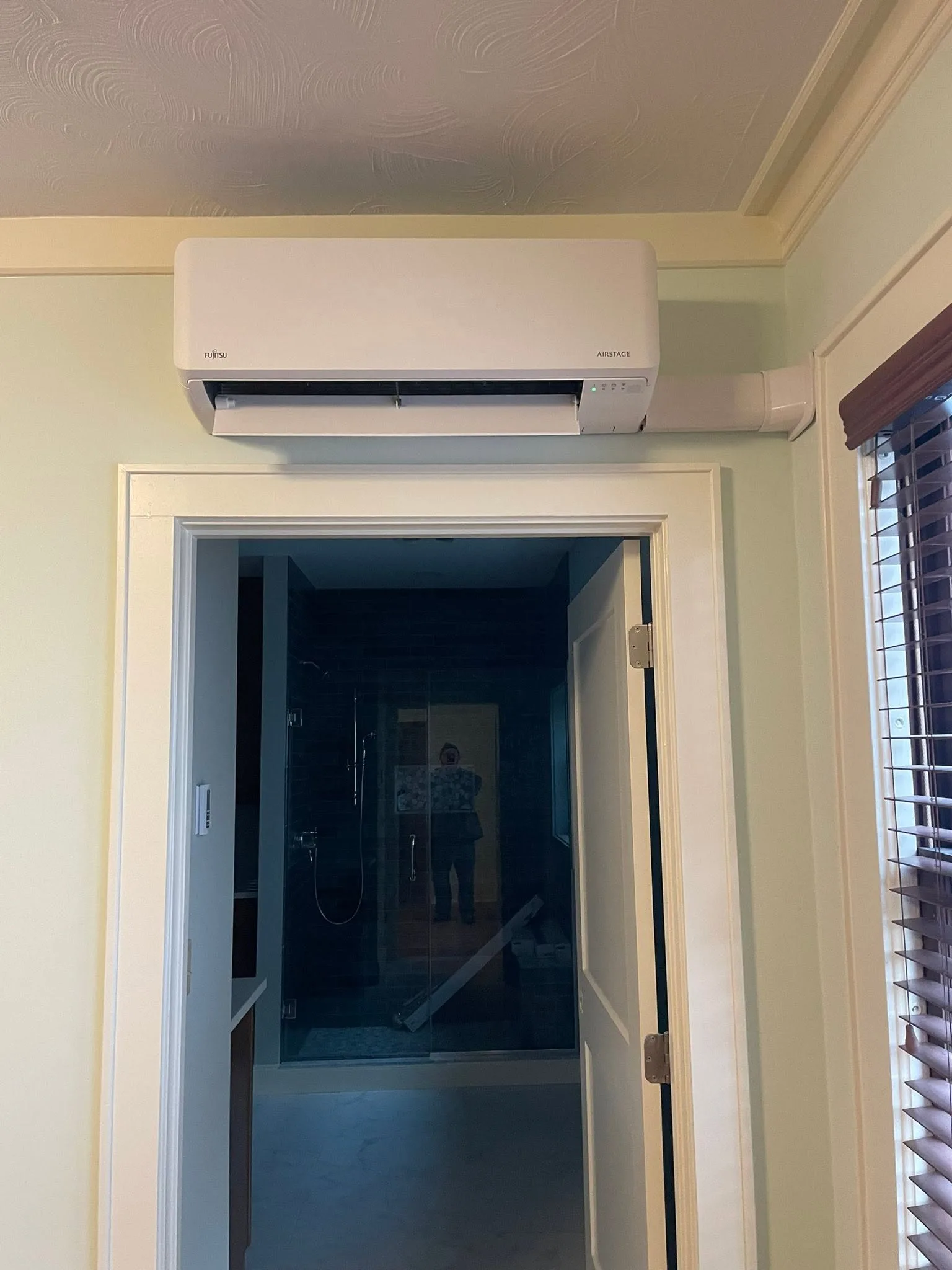 Finished Fujitsu indoor mini-split unit installation above a doorway