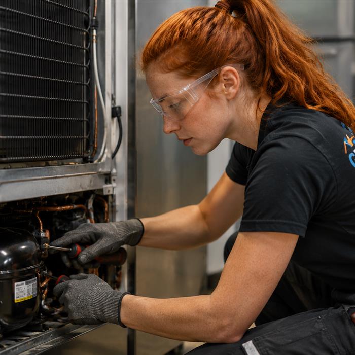 Technician servicing refrigeration equipment